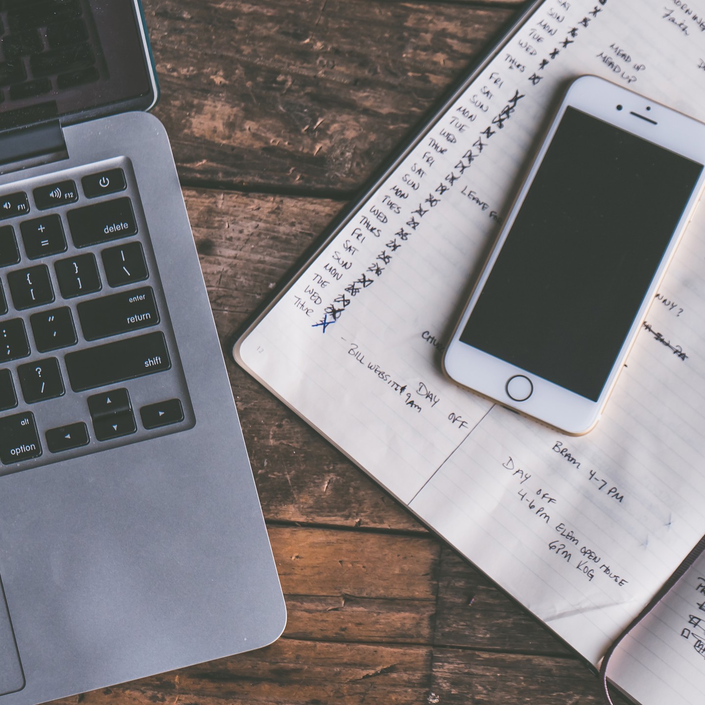 Laptop, phone and notebook on a desk