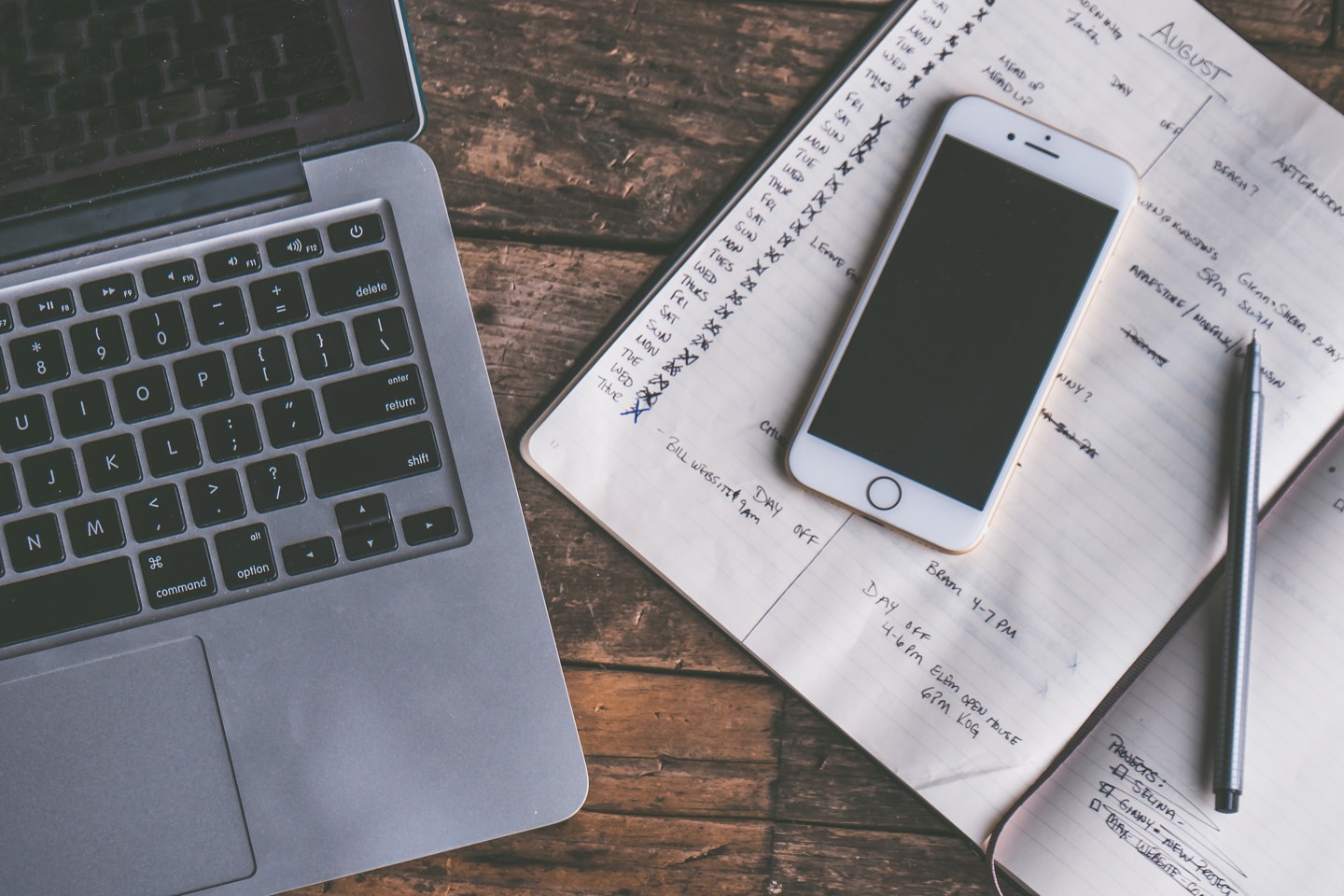 Laptop, phone and notebook on a desk